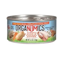 A 5.5 oz can of OrgaNOMics Turkey Duck & Chicken Dinner for Cats, part of a 24-pack, features a blue label with illustrations of poultry, carrots, and mushrooms, and is marketed as high protein as well as gluten and GMO free.